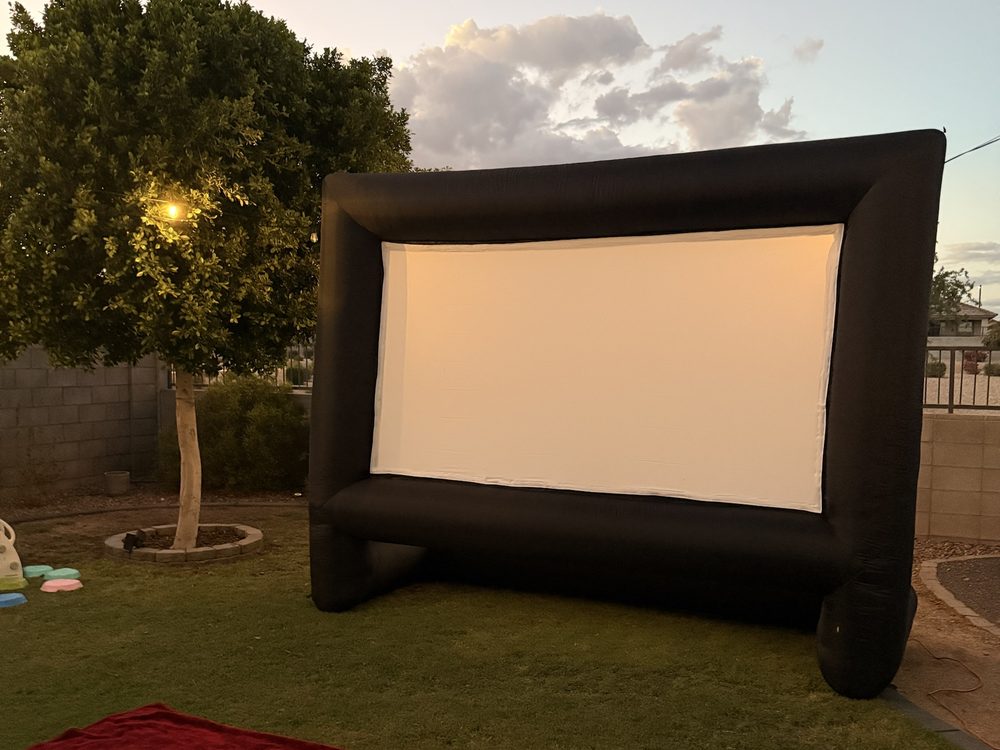 Backyard movie screen with string lights at sunset